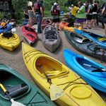 Colorful kayaks and people ready to kayak