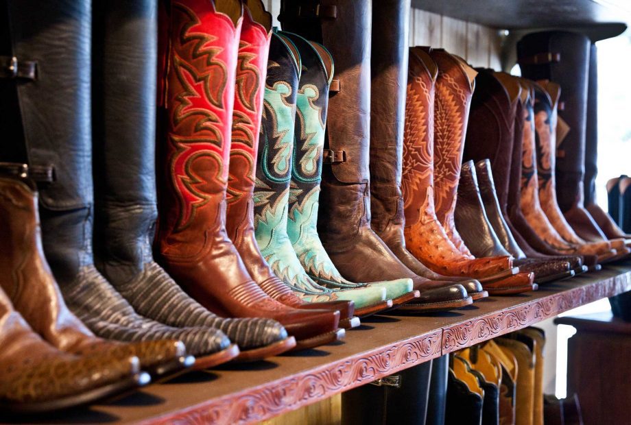 a shelf of leather cowboy boots